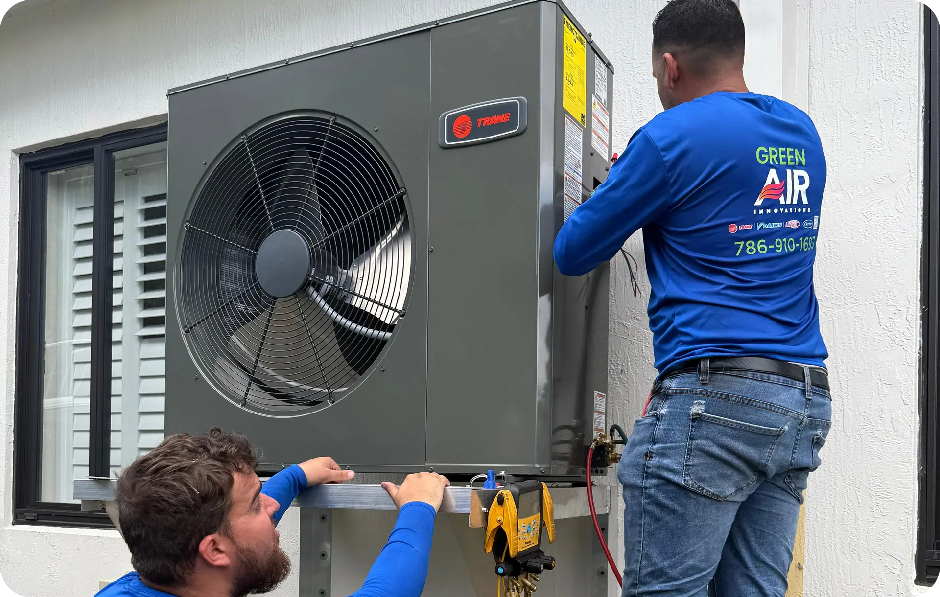 Technicians installing an outdoor AC condenser